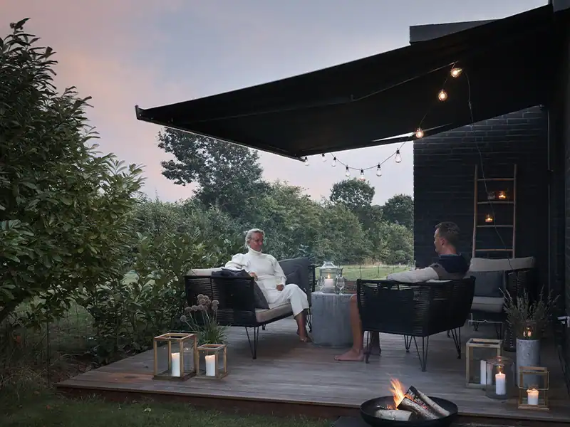Aftenhygge med levende lys på terrassen under en sigma markise